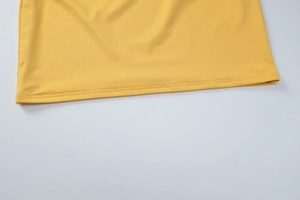 Gros plan sur l'ourlet en tissu jaune montrant les détails de couture à double aiguille