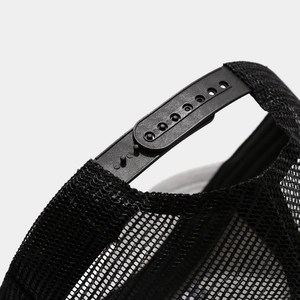Close-up of the adjustable black plastic snapback closure and breathable mesh on a trucker hat