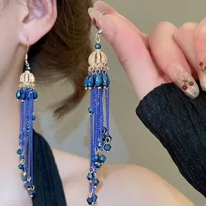 Elegant gold drop flower earrings with dark blue crystal tassels and long metal fringe