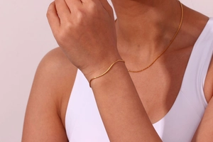 Detailed view of minimalist gold-plated stainless steel fine chain necklace set on model