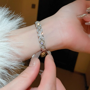 Close-up of silver crisscross quilted bracelet with sparkling zircon stones on wrist