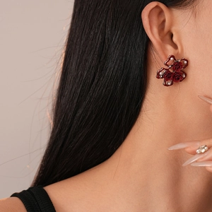Detail of red rose cluster earrings with pearls and vintage lace metal on ear