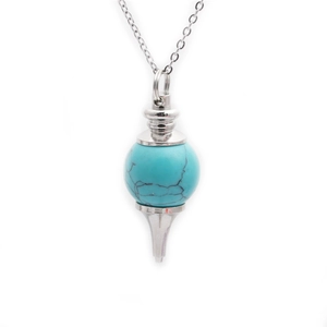 Close-up of turquoise round bead pendant with intricate silver hollow metalwork on chain