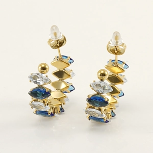 Detalle de pendientes en C bañados en oro de 18K con circonitas marquise azules y blancas
