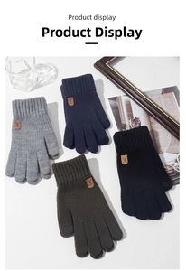 Detailed view of knitted winter gloves with leather reindeer patch and touchscreen tips