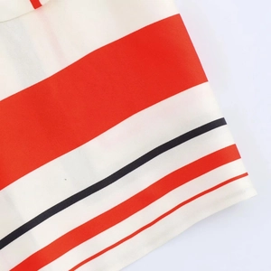 Close-up of red, black, and white striped fabric texture and stitched edge details