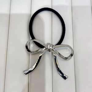 Minimalist silver bow metal hair tie with black elastic band on white background