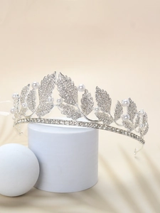 Detailed view of silver bridal crown featuring rhinestones, pearls and leaf motifs