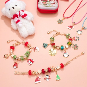 Détail d'un ensemble de bijoux de Noël avec bracelets dorés et breloques de fête colorées