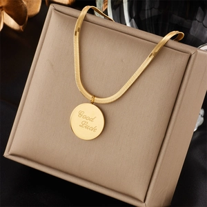 Detailed close-up of golden snake chain with engraved Good Luck round pendant