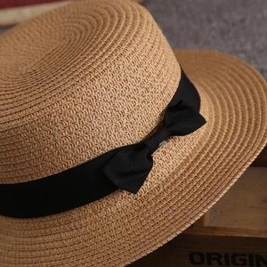 Classic straw boater hat with a black ribbon bow for summer beach and outdoor sun protection