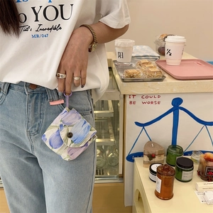 Mini floral tulip pouch with button closure hanging on denim jeans belt loop