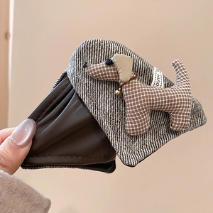 Close-up of flexible brown leather hair claw clip showing cute dachshund fabric patch detail