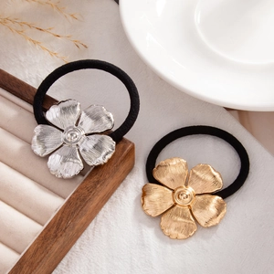 Close-up of elegant flower metal ponytail holders in gold and silver finish with elastic band