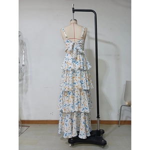 Detail of floral chiffon tiered maxi dress featuring thin straps and back bow tie
