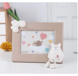 Detail of a beige cartoon photo frame with a 3D teddy bear and cloud relief decoration