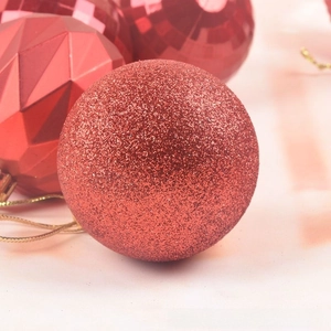 Close-up of 12 red Christmas balls with glittery, faceted, and matte textures for tree decor