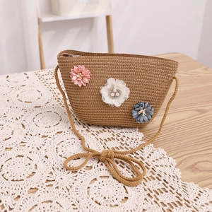 Détail du sac bandoulière en paille avec fleurs 3D et bandoulières tressées sur dentelle