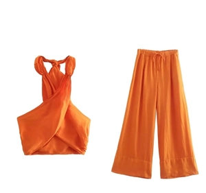 Detail von orangefarbenem Neckholder-Top und weiter Hose mit Tunnelzug aus Leinenstoff