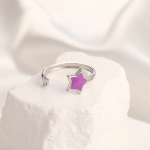 Detailed macro view of silver star ring with purple enamel inlay on white stone