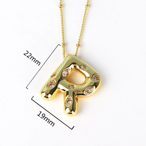 Detailed view of gold letter R pendant measuring 22mm by 19mm with inlaid crystals