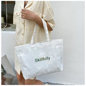 Close-up of a white transparent jelly tote bag featuring Skillfully green text on side