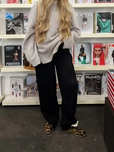 Elegante suéter de punto gris con bloques de color y pantalones anchos para estilo otoñal