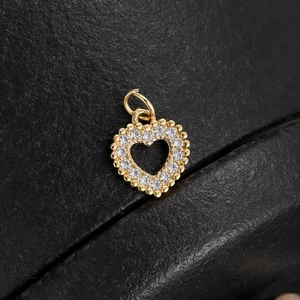Detail of 18K gold-plated heart pendant with sparkling cubic zirconia on black leather