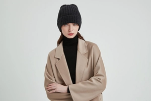 Close-up of black ribbed knit beanie hat showing detailed texture for winter wear