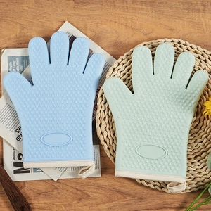 Heat-resistant silicone oven mitts with heart-shaped anti-slip texture on wood background