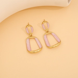 Macro detail of geometric gold earrings with pink marble enamel inlay on a beige background