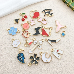 Assorted colorful enamel gold charms including heart, clover, and moon patterns