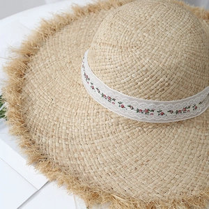 Chapeau de soleil en raphia avec broderie en dentelle et large bord effiloché de plage