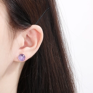 Macro shot of light purple faceted crystal stud earring worn on a model's ear