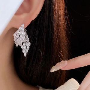 Macro close-up of luxurious marquise-cut zircon cluster earrings on model side view
