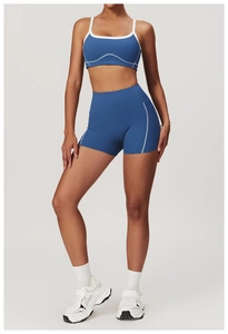 Vue de face d'un ensemble short de yoga bleu taille haute avec liseré blanc sur fond gris