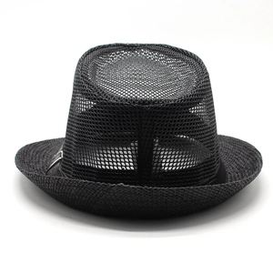 Vue détaillée de la couronne en maille noire et du bord en paille du chapeau Panama