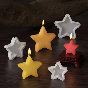 Stampi in silicone a forma di stella e candele colorate su sfondo decorativo in legno