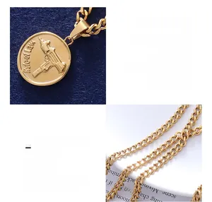 Detail of 18K gold-plated titanium necklace with engraved gun pendant and bold chain links