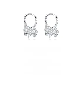 Detail of silver beaded hoop earrings featuring brilliant cut cubic zirconia charms