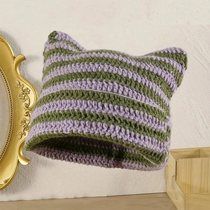 Close-up of green and lavender striped knit beanie with cat ear horn design