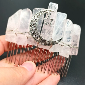 Detailed close-up of handmade rose quartz hair comb with silver moon and star charms