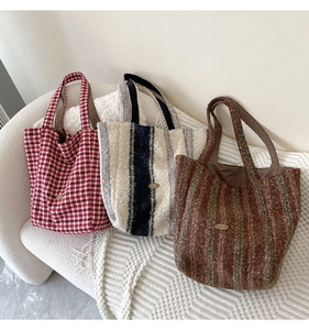 Detailed texture of fuzzy woolen tote bags with handmade metal logo in autumn setting