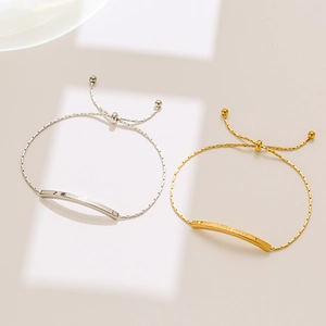 Detail of adjustable gold and silver bracelets with LOVER DREAM engraving and bead clasp