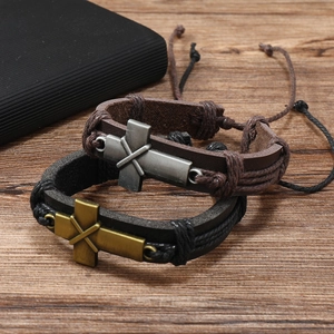 Retro multi-layer leather bracelets with metal cross charms on natural wood surface