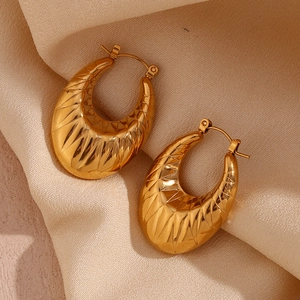 Macro shot of 18K gold plated hollow oval earrings with geometric textured patterns