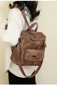 Nahaufnahme eines braunen Vintage-Rucksacks aus weichem Leder am Model getragen