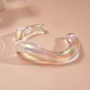 Macro shot of iridescent acrylic geometric bangle with iridescent wave shape and curves