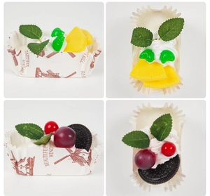 Close-up of artificial fruit cupcakes with cream, berries and decorative paper liners