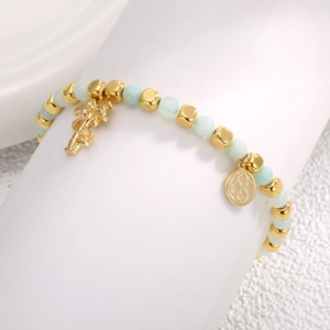 14k gold plated beaded bracelet with light green stones and palm tree charm on white base